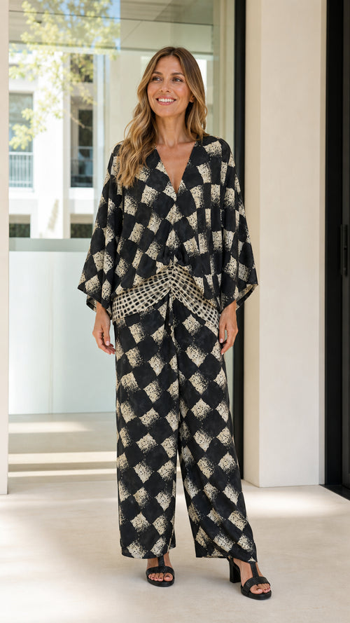 Woman wearing black geometric print two-piece set front view