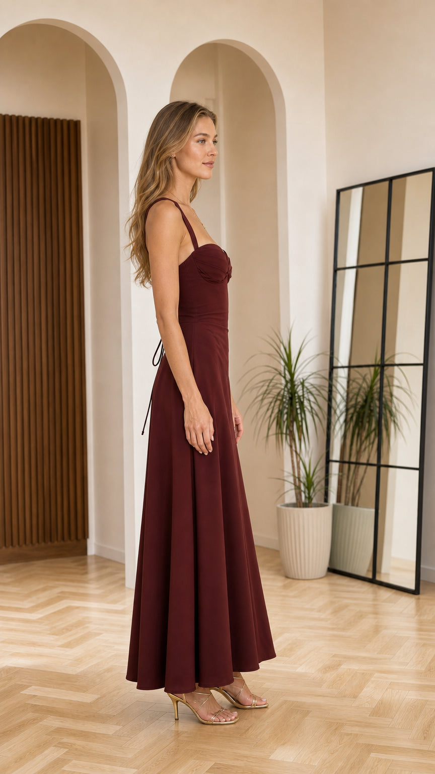 Side profile view of woman in burgundy maxi dress